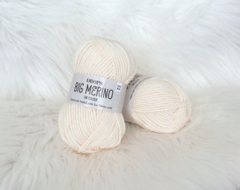 May include: Two balls of Drops Big Merino yarn in a cream colour. The yarn is superwash treated extra fine merino wool.