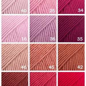 May include: A collection of 12 yarn skeins in various shades of pink, red, and brown. The skeins are arranged in a grid pattern with numbers printed on each skein.