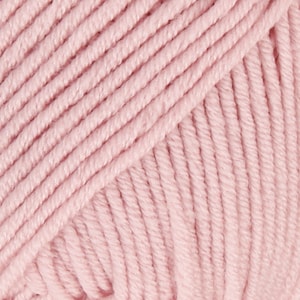 May include: Close-up of a soft, pink yarn ball. The yarn is made of a smooth, cotton-like material and is perfect for knitting or crocheting.