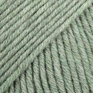 May include: Close-up of a skein of soft, green yarn. The yarn is made of wool and is perfect for knitting or crocheting.