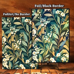 May include: Two floral art prints, one with a black border and one without. The prints feature a dark teal background with white flowers and green and gold leaves. The prints are displayed on a wooden surface.