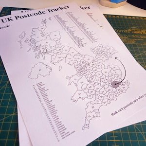May include: A black and white printed map of the UK, designed as a postcode tracker. The map shows postcode areas with labels and an arrow highlighting a specific region. Text includes "UK Postcode Tracker" and instructions for use. The map is on a white paper.