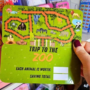 May include: A green and orange card with a map of a zoo and the text "Trip to the Zoo". The card has two blank spaces for writing in the value of each animal and the total savings.