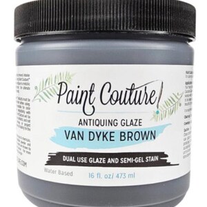 May include: A gray plastic jar with a black lid, labeled "Paint Couture" and "Van Dyke Brown Antiquing Glaze." The label also indicates it is a dual-use glaze and semi-gel stain, water-based, and contains 16 fl. oz. / 473 ml.