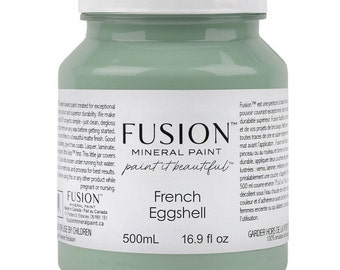 Puede incluir: Un bote de 500 ml de pintura mineral Fusion en color French Eggshell. La pintura es de color verde claro y el bote tiene una etiqueta blanca con el logotipo de Fusion y el nombre del color de la pintura. La etiqueta también incluye el texto "paint it beautiful".