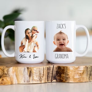 K&ouml;nnte beinhalten: Zwei wei&szlig;e Keramikbecher mit individuellen Fotos und Text. Ein Becher zeigt ein Foto von zwei Personen mit dem Text "Kim & Lea". Der andere Becher hat ein Babyfoto und den Text "Zack's Grandma".