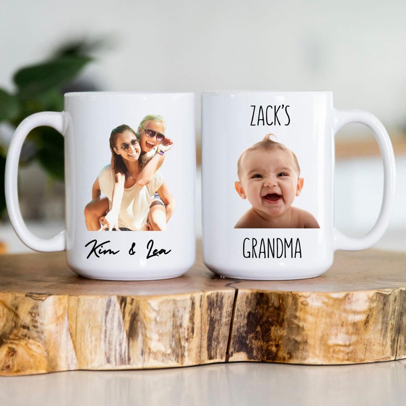 K&ouml;nnte beinhalten: Zwei wei&szlig;e Keramikbecher mit individuellen Fotos und Text. Ein Becher zeigt ein Foto von zwei Personen mit dem Text "Kim & Lea". Der andere Becher hat ein Babyfoto und den Text "Zack's Grandma".