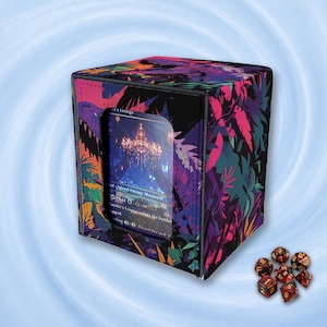 Op de afbeelding: Een vierkante deckbox met een levendig tropisch bladpatroon in roze, paarse en turquoise tinten. De voorkant heeft een doorzichtig venster dat een ruilkaart met een kroonluchterillustratie toont. Zeven veelzijdige dobbelstenen in rood en zwart.