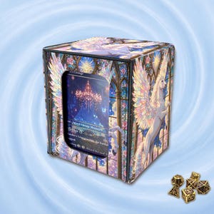 May include: A square deck box featuring a stained-glass style illustration of a winged unicorn with iridescent wings, containing a trading card visible through a front cutout. Five gold-coloured polyhedral dice with black numbering sit nearby.