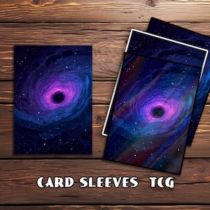 May include: Card sleeves with a striking cosmic design, showcasing a swirling galaxy in purple, blue, and black hues. The sleeves have a black border and are presented on a wooden surface. The text at the bottom reads "CARD SLEEVES TCG."