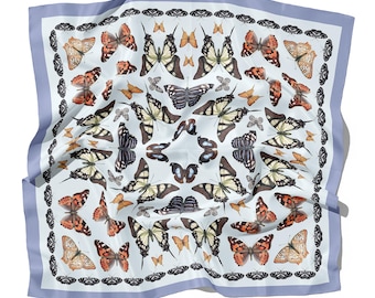 May include: A light blue silk scarf with a repeating pattern of colorful butterflies. The butterflies are arranged in a symmetrical pattern, creating a visually appealing design.