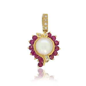 May include: A gold pendant featuring a white pearl surrounded by a halo of pink rubies and small diamonds.
