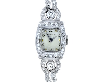 May include: A vintage Wittnauer wristwatch with a square face and diamond-encrusted band. The watch face is white with black Roman numeral hour markers and black hands.