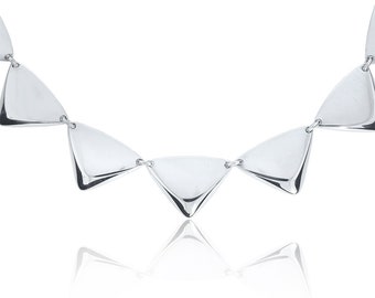 May include: A silver necklace with triangular pendant links. The necklace is made of polished metal and has a modern, geometric design.