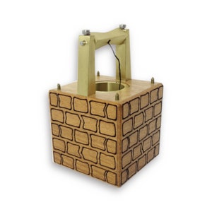 May include: A wooden box with a brick pattern and a brass handle. The box has a small opening at the top with a string hanging down.