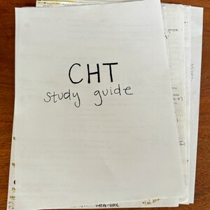 May include: A stack of white papers with the text "CHT Study Guide" written in black marker.