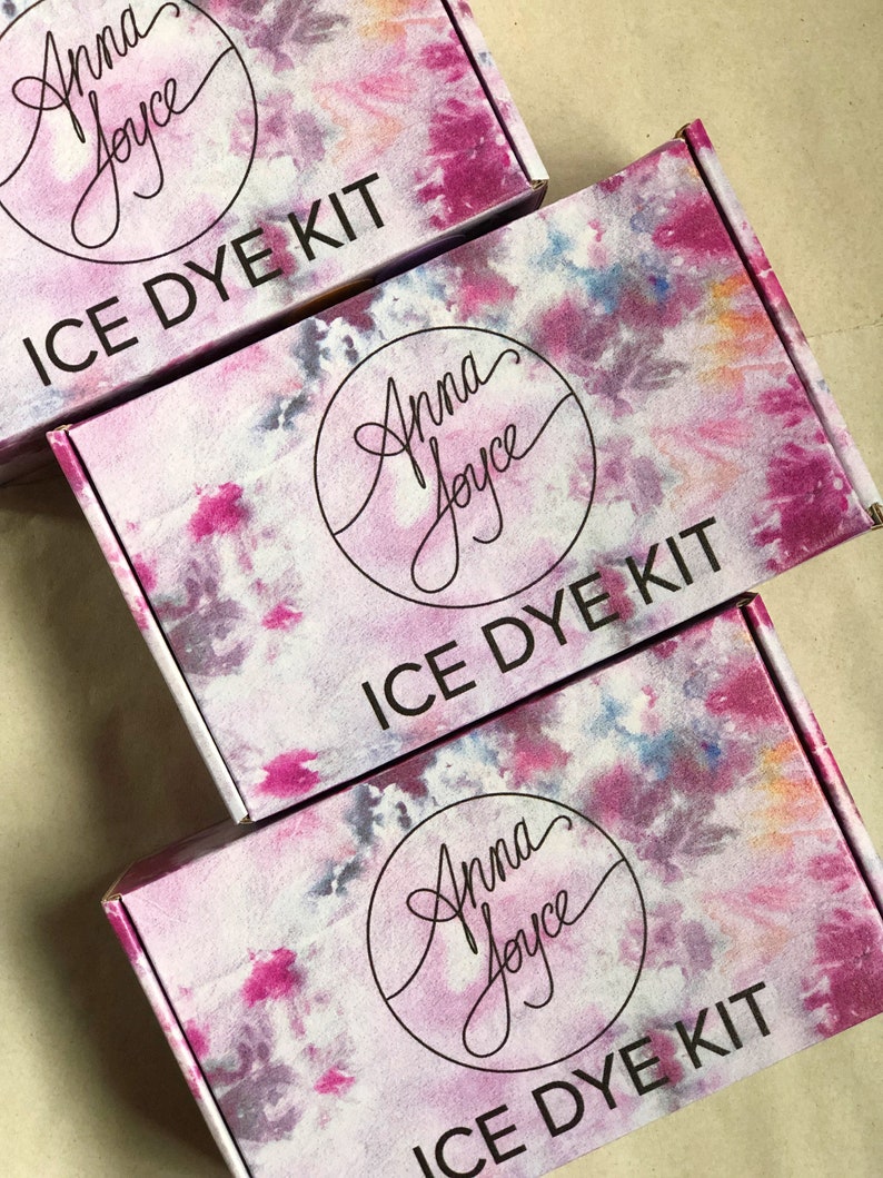 Może przedstawiać: Trzy pudełka z wzorem tie-dye i tekstem "Anna Joyce" w k&oacute;łku. Każde pudełko ma napis "ICE DYE KIT" nadrukowany z przodu.