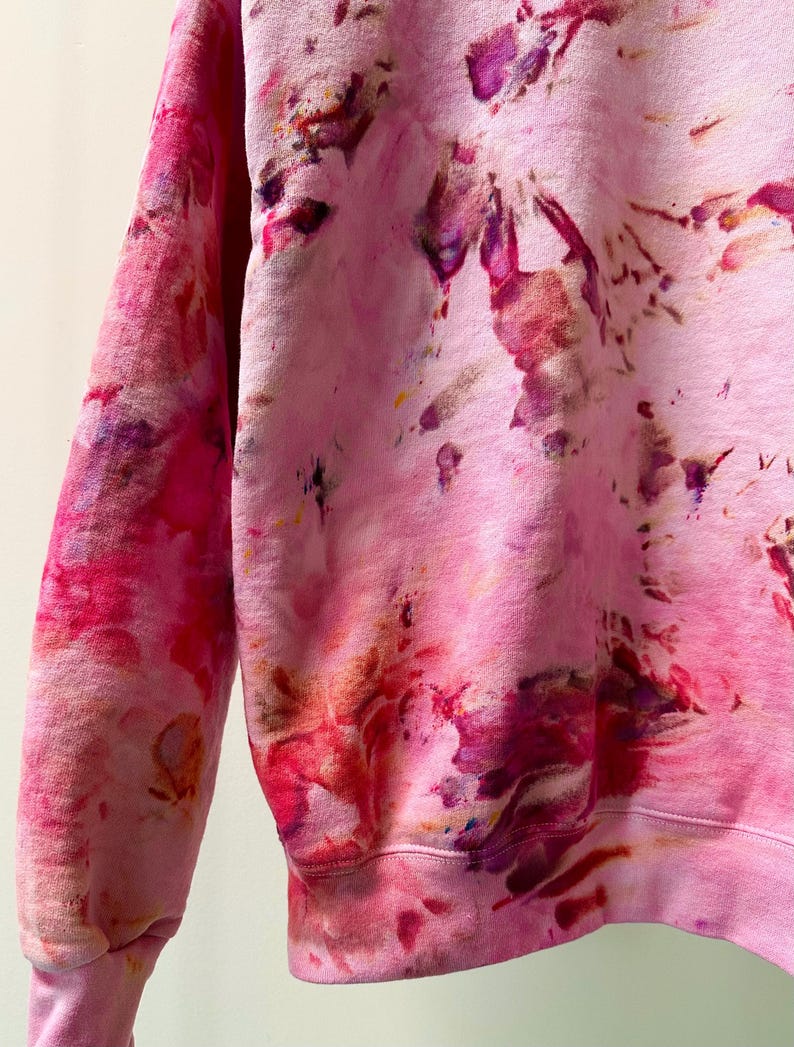 Op de afbeelding: Roze tie-dye sweatshirt met een losse pasvorm en lange mouwen. De sweatshirt heeft een uniek, abstract patroon met tinten roze, rood, paars en bruin.