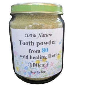 May include: A glass jar with a green lid filled with a light brown powder. The label reads "100% Nature Tooth powder from 80 wild healing Herbs 100cm3 Best before:"