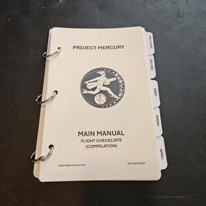 Peut inclure: Un manuel principal Project Mercury de couleur crème avec des listes de contrôle de vol. La couverture présente un emblème circulaire avec un astronaute en course. Le manuel a des reliures à anneaux métalliques et des onglets étiquetés.
