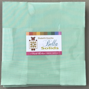 May include: A square of light green Bella Solids fabric with a label that reads "Elizabeth's Favorites" and "Bella Solids" in a script font. The label also includes the "moda FABRICS + SUPPLIES" logo.