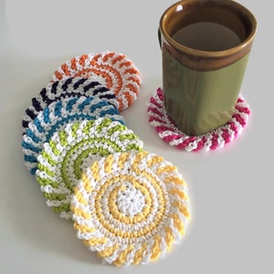 May include: Set of six colorful crocheted coasters with a swirl pattern. The coasters are in shades of pink, orange, yellow, green, blue, and purple.
