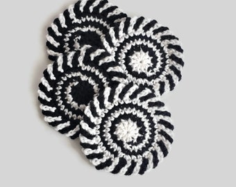 May include: Three black and white crocheted coasters with a spiral pattern. The coasters are stacked on top of each other.