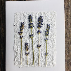 A handmade paper note card with pressed lavender.