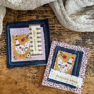 May include: Two fabric coasters with a denim border and a chicken design. One coaster has a white and red polka dot pattern, and the other has a floral pattern. Both have a mustard yellow center with a white chicken and the text "CHICKEN LADY".
