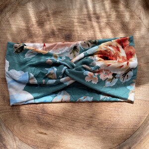 May include: A green and white floral patterned headband with a twisted knot in the center.