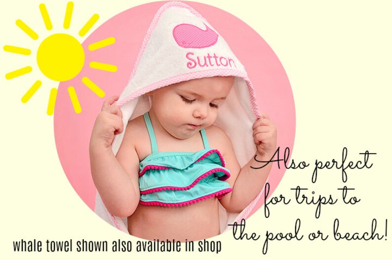 May include: A white hooded baby towel with a pink whale design and the name "Sutton" embroidered on it. The towel has a pink trim. The baby is wearing a turquoise swimsuit with pink trim. A yellow sun graphic is in the background.