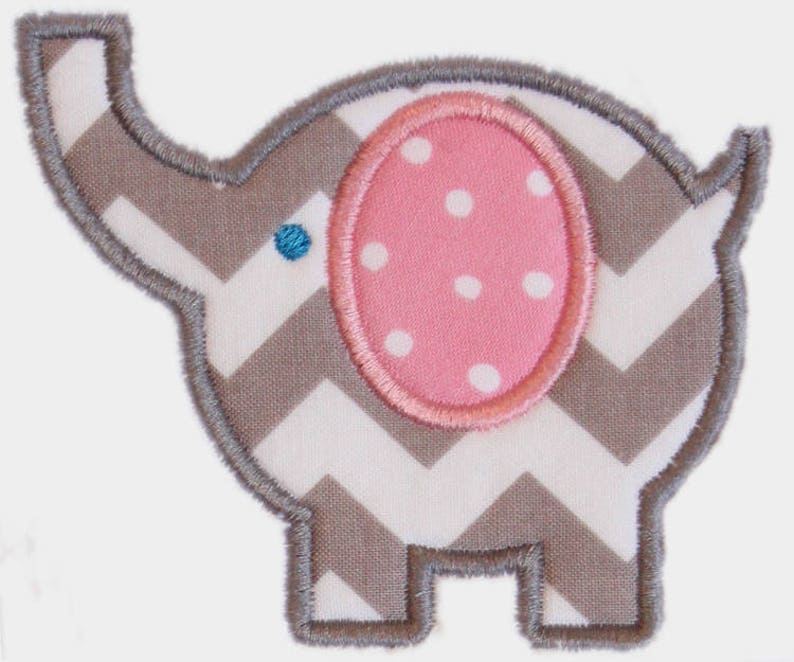May include: An embroidered elephant applique with a gray and white chevron pattern body. The elephant has a pink ear with white polka dots and a blue eye. The applique is outlined with gray stitching.