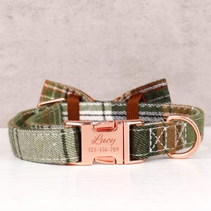 May include: A green plaid dog collar with a matching bow tie. The collar has a rose gold buckle engraved with the name "Lucy" and a phone number. The collar is designed for pets.