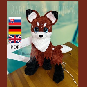 Puede incluir: Patrón de crochet para un juguete amigurumi de zorro. El patrón está disponible en formato PDF e incluye instrucciones en inglés, alemán, eslovaco y checo. El patrón es para un zorro marrón con detalles blancos y ojos negros.