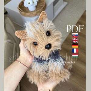 Può includere: Un cane di peluche realizzato con pelliccia sintetica color marrone chiaro e grigio scuro, con orecchie a punta, occhi in plastica nera e naso nero. Il testo PDF è visibile sul lato destro, accompagnato da una colonna di cinque bandiere.