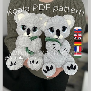 May include: Two gray crochet koala bears with black eyes and noses, wearing green scarves. The text "Koala PDF pattern" is above the koalas. The bears are handmade and fluffy.