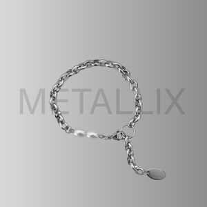 May include: A silver-toned chain bracelet with a small chain extension and a small oval charm. The bracelet features a series of oval links and three white pearls. The word "METALLIX" is printed in gray.