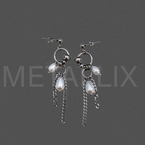 May include: A pair of silver-toned dangle earrings featuring a circular hoop design, small metallic spheres, teardrop-shaped white faux pearls, and delicate hanging chain links. The earrings are secured with a standard post and butterfly back closure.