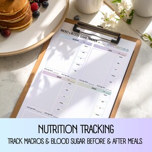 May include: A clipboard holding a nutrition tracking sheet. The sheet is white with sections for breakfast, lunch, dinner, and snacks, with spaces to track macros and blood sugar before and after meals. Text at the bottom reads "NUTRITION TRACKING" and "TRACK MACROS & BLOOD SUGAR BEFORE & AFTER MEALS."