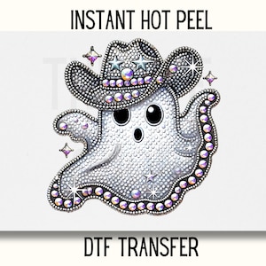 May include: A white ghost wearing a silver and purple rhinestone cowboy hat. The ghost has a rhinestone design and the text "INSTANT HOT PEEL" and "DTF TRANSFER" are printed on the image.