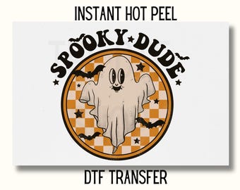 May include: A white ghost with a friendly face and a checkered background. The ghost is inside a circle with the text "Spooky Dude" in a retro font. The text "Instant Hot Peel DTF Transfer" is below the circle.