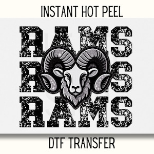 May include: A black and white graphic design of the word "RAMS" repeated three times with a distressed look. A silver glitter ram head is centered between the words. The text "INSTANT HOT PEEL" is at the top of the image and "DTF TRANSFER" is at the bottom.
