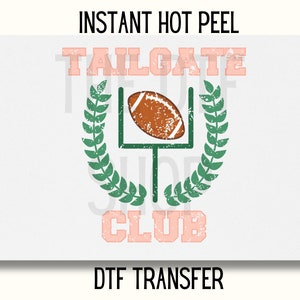 May include: Instant hot peel DTF transfer with a distressed design featuring a football in a goal post with a green laurel wreath and the text "TAILGATE CLUB" in pink.