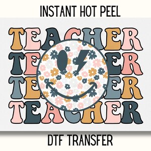 May include: A digital transfer design featuring the word "TEACHER" repeated four times in a retro style font. The word is in shades of pink, blue, and yellow. A smiley face with a lightning bolt and a floral pattern fills the space between the words.