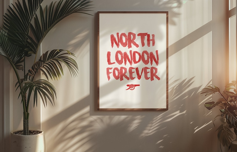 May include: A framed print with the words "North London Forever" in red brush lettering. The Arsenal Football Club crest is below the text.