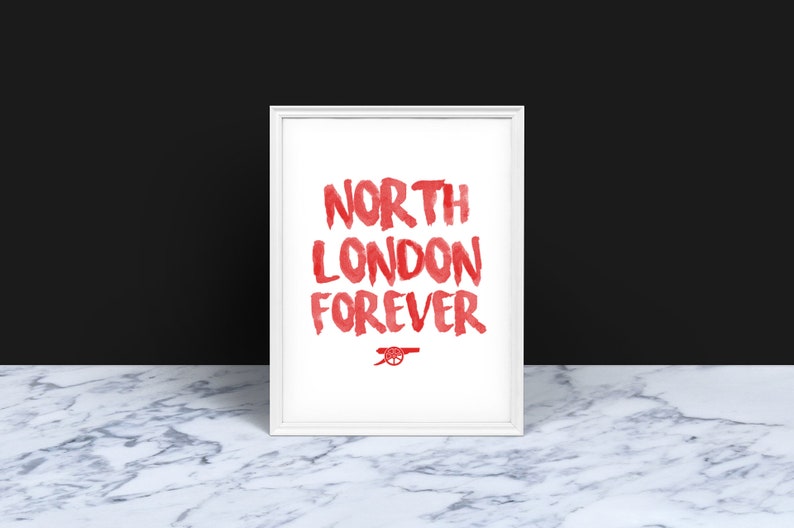 May include: White framed print with red text that reads "North London Forever" and a red cannon logo.