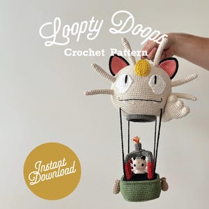 Może przedstawiać: Wzór na szydełku na biało-różowy balon na gorące powietrze z żółto-białą postacią w środku. Balon ma kształt kota z białą twarzą i czarnymi oczami. Wzór nazywa się "Loopy Doops Crochet Pattern" i zawiera etykietę "Natychmiastowe pobranie".