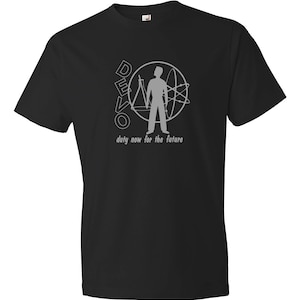Op de afbeelding: Zwart T-shirt met een grijze afbeelding van een persoon die in een cirkel staat met het woord "DEVO" en de tekst "duty now for the future".