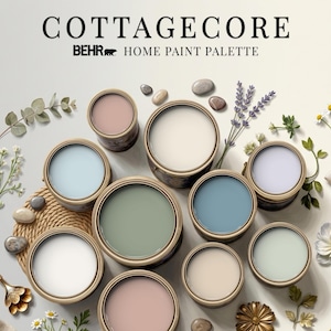 Pode incluir: Uma paleta de tintas Behr intitulada COTTAGECORE com dez latas de tinta abertas em vários tons pastel, incluindo verde sálvia, azul celeste, lavanda, creme e rosa suave, dispostas com ramos de lavanda, margaridas e pequenas pedras.