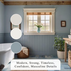 May include: Bathroom interior design featuring a freestanding white bathtub, light blue walls, and white wainscoting.  A wooden vanity with a vessel sink and beige and blue color palettes are shown. The text 'Modern, Strong, Timeless, Confident, Masculine Details' is displayed below the image.